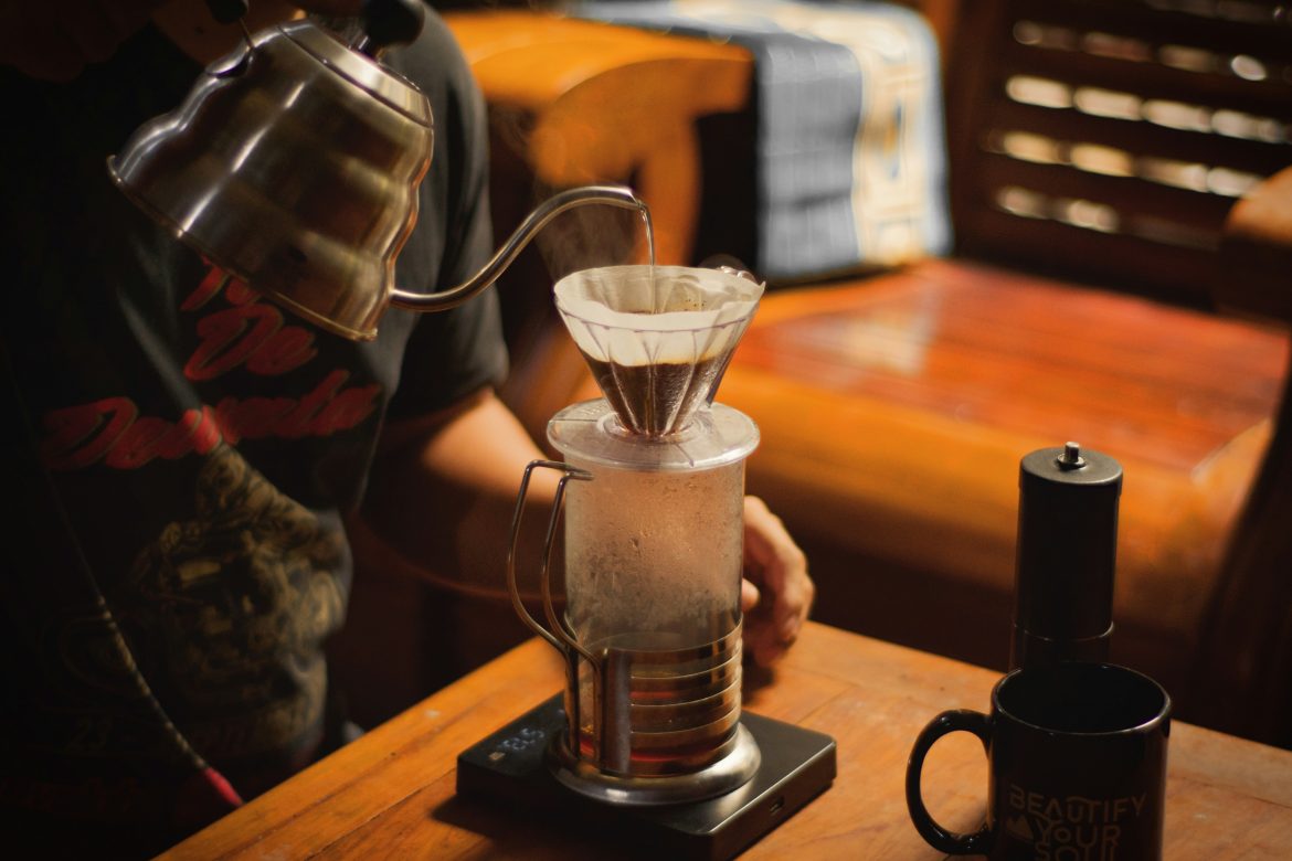 barista pouring water over coffee filter